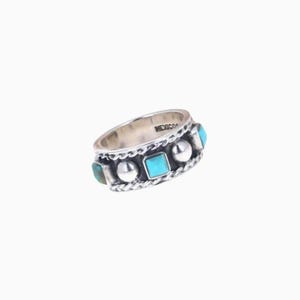 May include: A silver ring with turquoise and silver accents. The ring features a series of turquoise stones and silver beads, with a braided design along the edges. The word "MEXICO" is stamped on the inside of the ring.