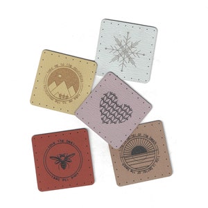 May include: Five fabric patches with various designs and sayings. The patches are beige, pink, brown, and red. The sayings on the patches include "Take me to the mountains", "Save the bees", "Like better at the beach", and a snowflake design.