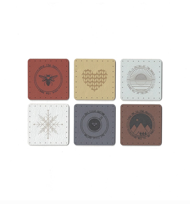May include: Six square-shaped coasters with different designs and sayings. The coasters are made of a textured material that resembles leather. The designs include a bee, a heart, a sunset, a snowflake, a coffee cup, and mountains.