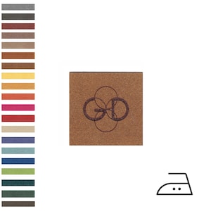 May include: A square, brown label featuring the letters "GD" in a circular design, in a darker brown. A colour palette of various shades of brown, grey, and other colours is on the left. An iron symbol is on the right.