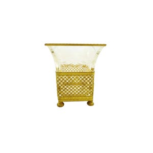 May include: A clear glass vase with an etched design sits on a gold metal stand with a square base and four legs.