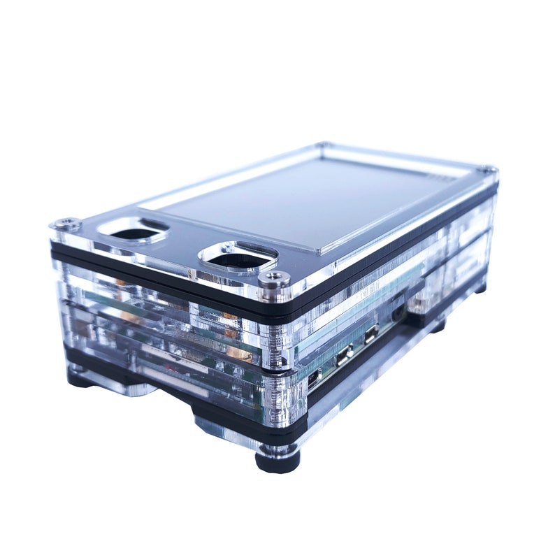 May include: A clear plastic case with a black trim, designed to hold a small computer or electronics. The case has a built-in screen and multiple ports.
