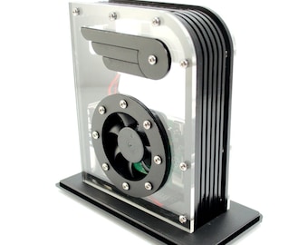 Op de afbeelding: Een zwarte en transparante acrylbehuizing met een kleine ventilator en een zwart vleugelvormig onderdeel erin. De behuizing heeft een zwarte basis.