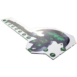 May include: A clear acrylic game board shaped like an axe with a green and black design. The board has a number of small circles around the edge.