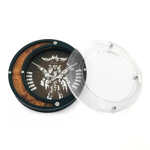 May include: A round wooden coaster with a black border and a clear plastic lid. The coaster features a detailed white graphic of a skeleton cowboy holding two pistols. The word "bullets" is printed on the coaster.
