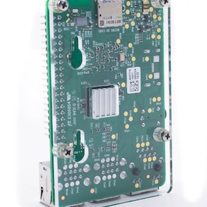 May include: A green circuit board with a clear plastic case. The board has a micro SD card slot, a network port, and several other components. The text "XE305654 JX02 94V-0 325" is printed on the board.