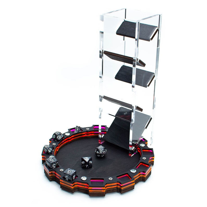 Op de afbeelding: Een zwarte houten dobbelsteenbak met een transparante acryltoren om dobbelstenen te rollen. De bak heeft een meerkleurige ring rond de rand en een zwarte viltbodem. De toren heeft drie planken om dobbelstenen op te bergen.