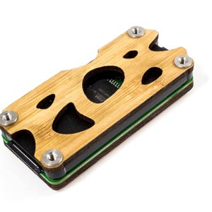 Op de afbeelding: Een houten kist met een uitgesneden ontwerp, met een zwarte printplaat erin. De kist heeft een groene en zwarte voering en is vastgeschroefd met zilveren schroeven.