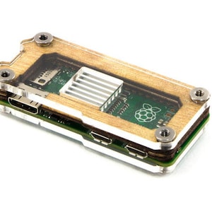 Puede incluir: Una caja transparente de acrílico con chapa de madera para una computadora Raspberry Pi. La caja tiene un disipador de calor integrado y se asegura con tornillos.