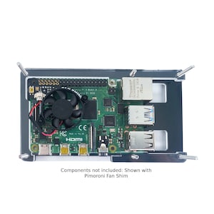 May include: A green Raspberry Pi 4 Model B computer board with a black fan, a black case, and four silver standoffs. The board has a HDMI port, a micro USB port, and an Ethernet port. The text "Raspberry Pi 4 Model B" and "C.H.I.P.S. 2018" are visible on the board.