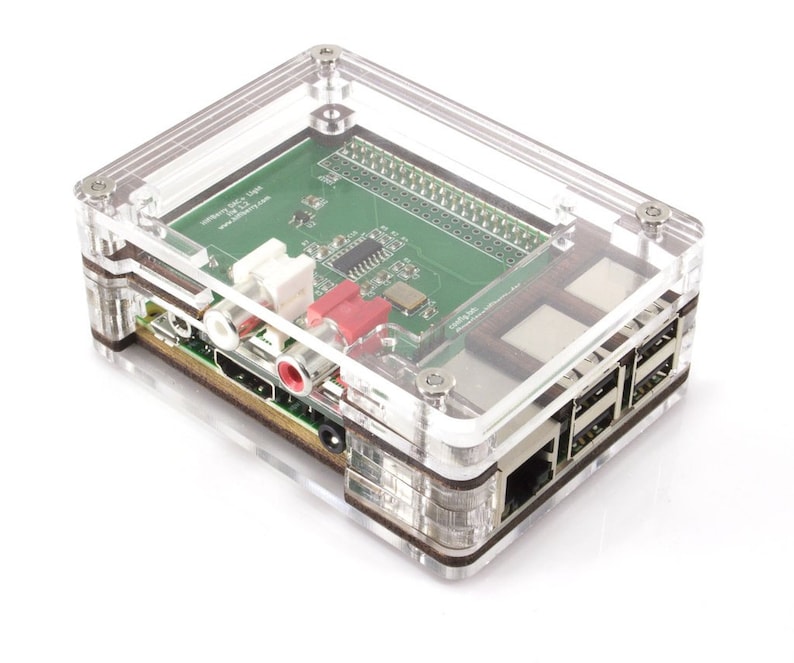 Op de afbeelding: Een transparante plastic behuizing voor een Raspberry Pi-computer. De behuizing heeft een groene printplaat met verschillende poorten en connectoren. De behuizing is ontworpen om de Raspberry Pi en zijn componenten te beschermen.