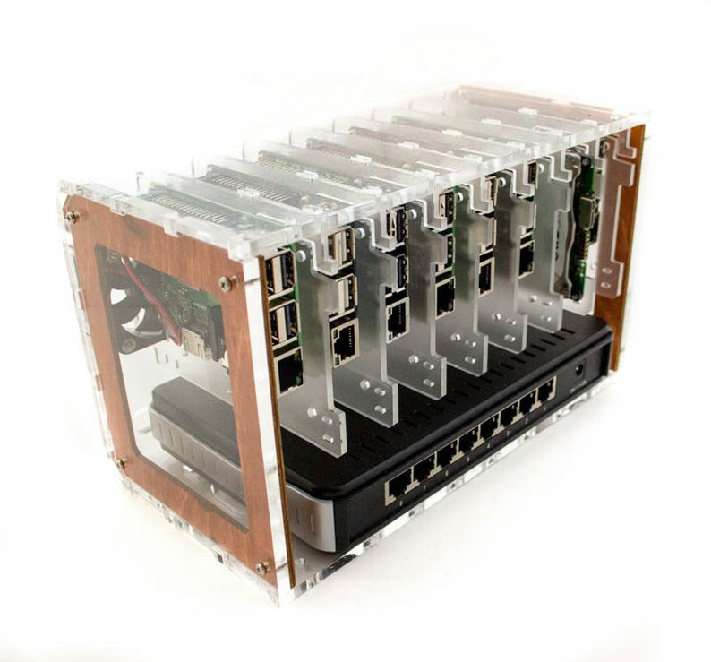 May include: A clear acrylic case with a wooden trim holds multiple Raspberry Pi computers. The case has a black network switch with multiple ports.