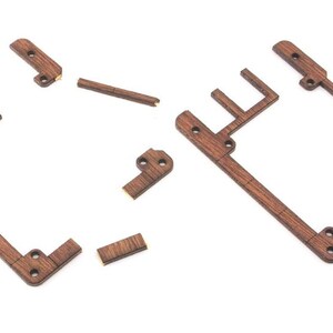 Op de afbeelding: Een set houten onderdelen voor het bouwen van een klein houten frame. De onderdelen zijn bruin en hebben een natuurlijke houten afwerking.
