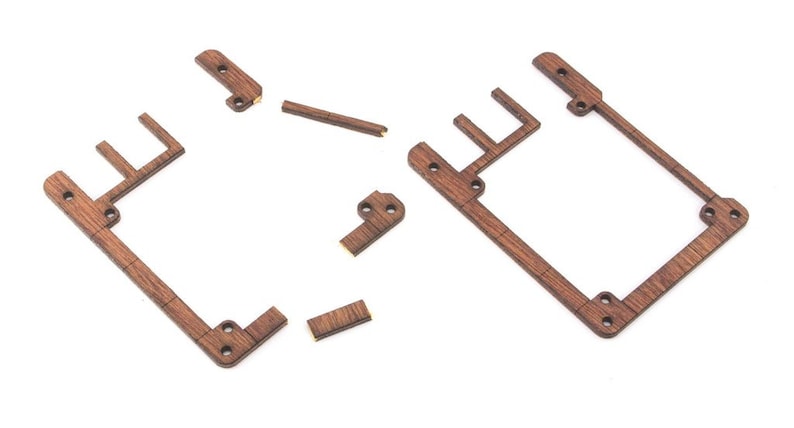 Op de afbeelding: Een set houten onderdelen voor het bouwen van een klein houten frame. De onderdelen zijn bruin en hebben een natuurlijke houten afwerking.