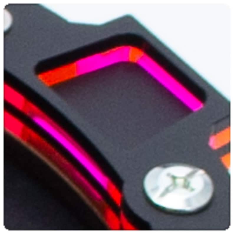 Op de afbeelding: Close-up van een zwart metalen object met een roze en oranje LED-lampje. Het lampje heeft de vorm van een vierkant en is omgeven door een zwarte rand.