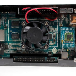 Peut inclure: Gros plan sur une carte de circuit imprimé avec un ventilateur noir, une petite antenne et un connecteur noir. La carte est verte et comporte plusieurs composants.