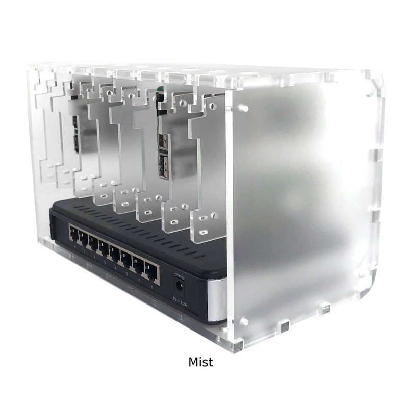 May include: A clear acrylic case with a black network switch inside. The case has slots for multiple devices and the text "Mist" is printed on the bottom.