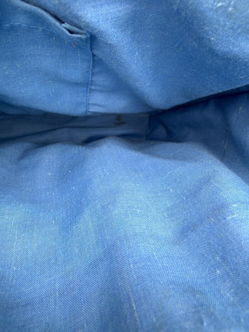 K&ouml;nnte beinhalten: Innenansicht einer blauen Stofftasche. Das Innere der Tasche ist einfarbig hellblau, mit sichtbaren N&auml;hten und einer leicht strukturierten Oberfl&auml;che. Der Stoff scheint ein robustes Material zu sein, m&ouml;glicherweise Segeltuch oder ein &auml;hnliches Textil.