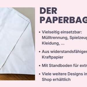 K&ouml;nnte beinhalten: Ein wei&szlig;er Papiersack mit flachem Boden und gefalteter Ecke, neben dem Text: DER PAPERBAG, Vielseitig einsetzbar: M&uuml;lltrennung, Spielzeug, Kleidung, Aus widerstandsf&auml;higem Kraftpapier, Mit Standboden f&uuml;r extra Halt, Viele weitere Designs im Shop erh&auml;ltlich.