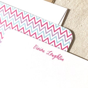May include: White stationery with a pink chevron border and the name "Vivian Loughlin" printed in pink.