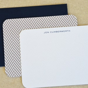 May include: A white card with rounded corners and a gray chevron pattern border. The card has the name "JON CUMBERWORTH" printed in blue ink at the top.
