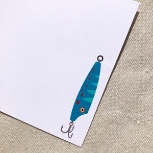 May include: A blue and green fishing lure with red dots and a silver hook. The lure has a black eye.