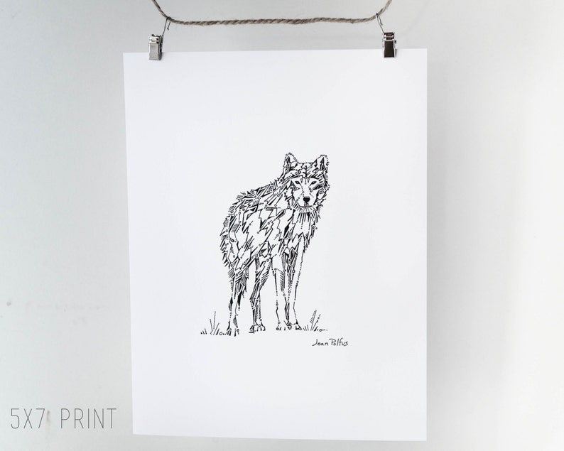 May include: A black and white print of a wolf, rendered in a geometric style. The artwork is on a white paper, and the print is labeled "5x7 PRINT". The print is hanging from a clothesline.