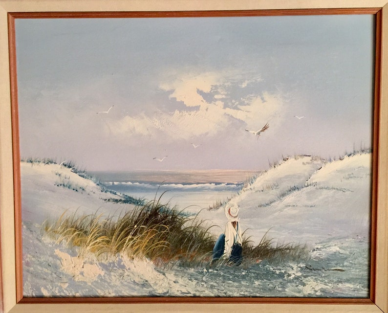 May include: A painting of a seascape with a lone figure sitting on a sandy beach, looking out at the ocean. The sky is a soft blue with white clouds, and there are a few seagulls flying overhead.