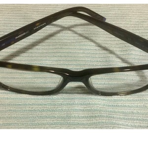 May include: A pair of tortoiseshell eyeglasses with clear lenses. The arms of the glasses are marked "Downtown" and "Marcolin".