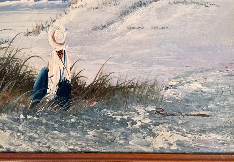 May include: A painting of a person wearing a white hat and blue clothing standing in tall grass by a body of water. The painting is signed "R.W." in the bottom right corner.