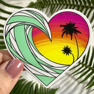May include: Heart-shaped sticker featuring a stylized ocean wave in shades of green and white, framing a sunset scene with palm trees. The sunset transitions from yellow to orange and purple. The text "epb_creations" is in the upper right corner.