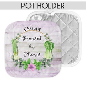 May include: A purple and white pot holder with a green leafy wreath and the text "Vegan Powered by Plants".