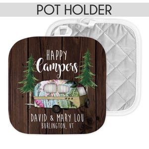 May include: A brown wood pot holder with a white quilted back. The front features a floral patterned camper with the text "Happy Campers" and "David & Mary Lou Burlington, VT".