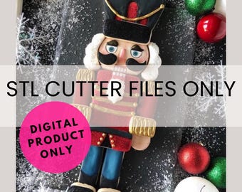 May include: A digital download STL cutter file for a nutcracker cookie cutter. The image shows a decorated gingerbread nutcracker cookie with red, gold, and blue details. The text "STL CUTTER FILES ONLY" and "DIGITAL PRODUCT ONLY" is visible in the image.