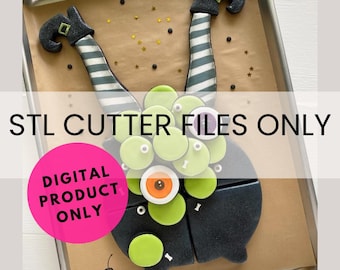May include: A digital download of STL cutter files for a witch's legs and a monster cookie cutter. The image shows the cookie cutters on a baking sheet with a pink circle that says "Digital Product Only".