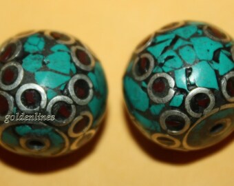 May include: Two turquoise and silver round beads with red accents. The beads are made of turquoise, silver, and red stones.