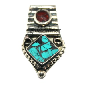 May include: Silver pendant with a turquoise and red stone inlay. The pendant has a decorative design and is a great addition to any jewelry collection.