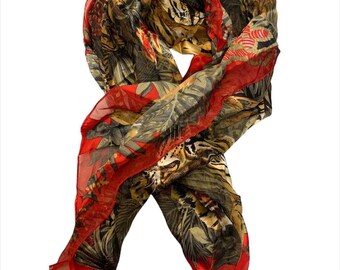 Puede incluir: Una bufanda de seda roja y verde con estampado de tigre y hojas tropicales.