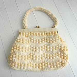 Cartera vintage de los años 50 con asa superior con cuentas gruesas, marco de metal dorado con detalles de nácar y lucita y cierre de boquilla, estilo veraniego de mediados de siglo