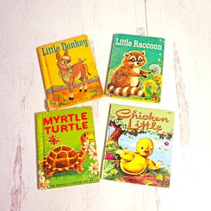 May include: Four vintage children's books with colorful covers featuring illustrations of a donkey, raccoon, turtle, and a chick. The books are titled "Little Donkey", "Little Raccoon", "Myrtle Turtle", and "Chicken Little".