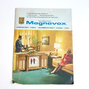 May include: A vintage advertisement for Magnavox televisions featuring a couple in a living room. The ad highlights the brand's commitment to high-quality entertainment experiences with features like stereo high fidelity, color TV, and fully automatic big picture TV.