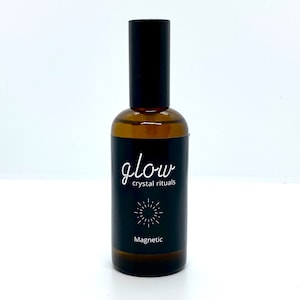 Pode incluir: Uma garrafa de vidro marrom com um borrifador preto e um rótulo. O rótulo diz "glow crystal rituals" e "Magnetic".