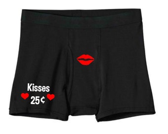 May include: Black boxer shorts with a red lip print and the text "Kisses 25¢" with two red hearts.