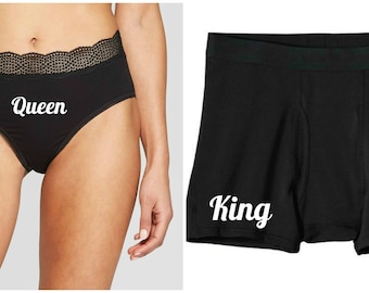 May include: Black underwear with a lace trim and the word "Queen" printed in white.  Black boxer shorts with the word "King" printed in white.