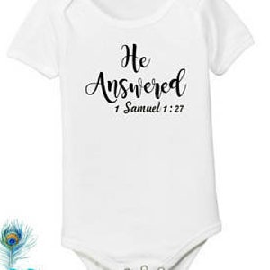 Pode incluir: Macac&atilde;o branco para beb&ecirc; com texto preto que diz "Ele respondeu" e "1 Samuel 1:27".