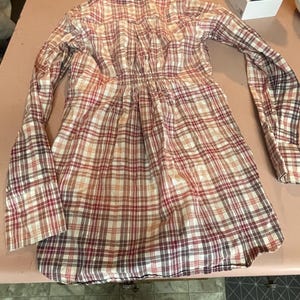 Op de afbeelding: Een geruit shirt met lange mouwen in tinten rood, bruin en cr&egrave;me. Het shirt heeft een geplooide taille en manchetten met knopen. De stof heeft een klassiek ruitpatroon.