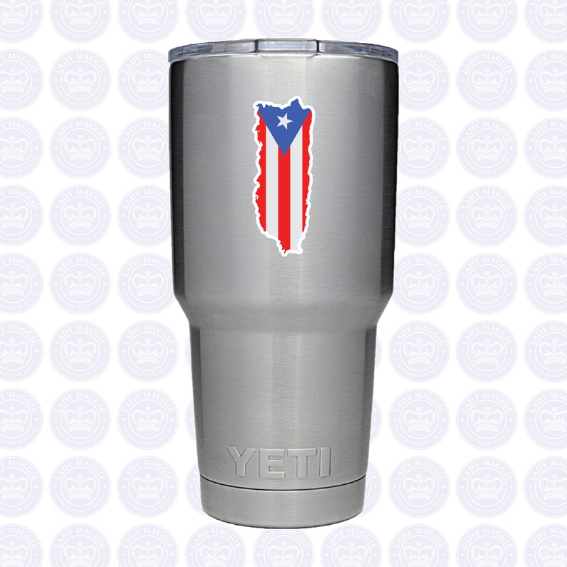 May include: A silver Yeti tumbler with a sticker of the Puerto Rican flag on the front. The flag is red, white, and blue with a star in the upper left corner.