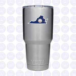 May include: A stainless steel Yeti tumbler with a Virginia state flag sticker. The sticker features a dark blue outline of the state with a circular emblem. The Yeti logo is visible at the bottom.