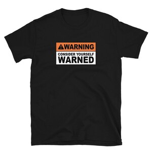 May include: Black t-shirt with an orange warning sign that says "WARNING CONSIDER YOURSELF WARNED".