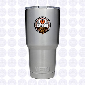 May include: A silver Yeti tumbler with a black and orange sticker that says "National Weather Service Advanced SKYWARN Storm Spotter".